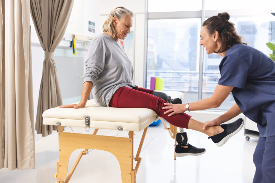 Physical therapist assisting a senior patient during a physical therapy session